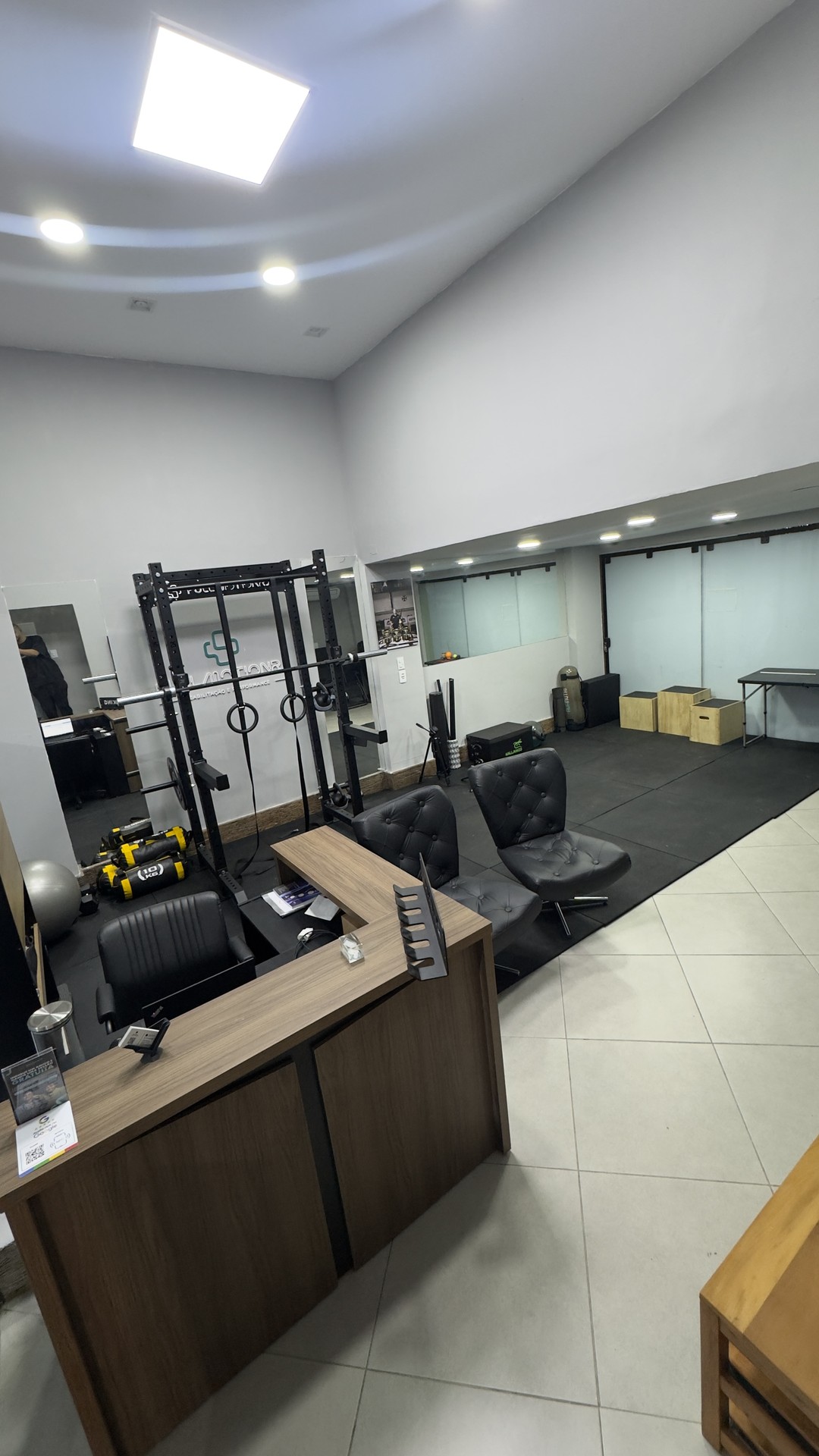 Recepção e sala de treino da Fullmotion no Recreio dos Bandeirantes, com rack de agachamento, argolas, sandbags e caixas pliométricas